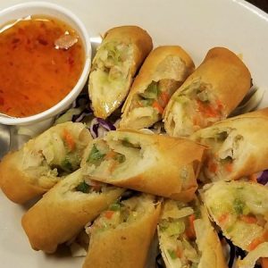Deep fried egg rolls dip in Thai sweet and sour sauce.